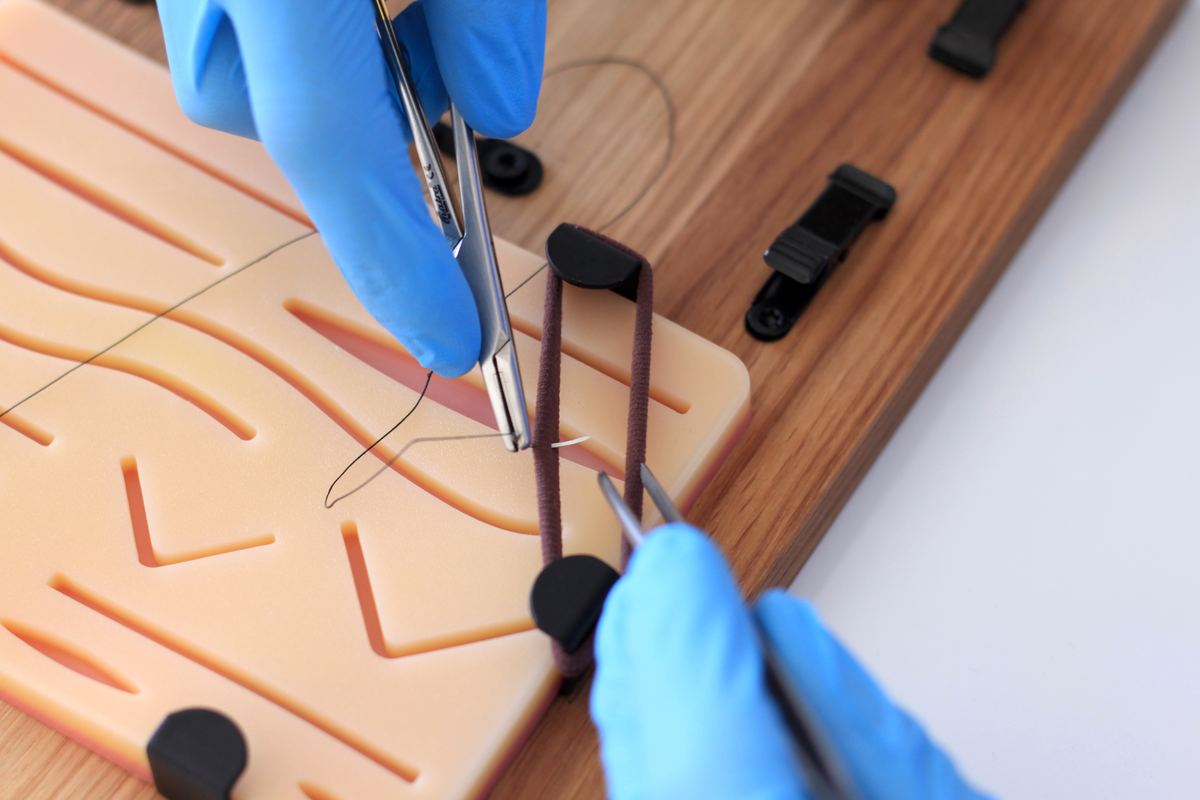 Suturing the silicone pad with needle holder and forceps